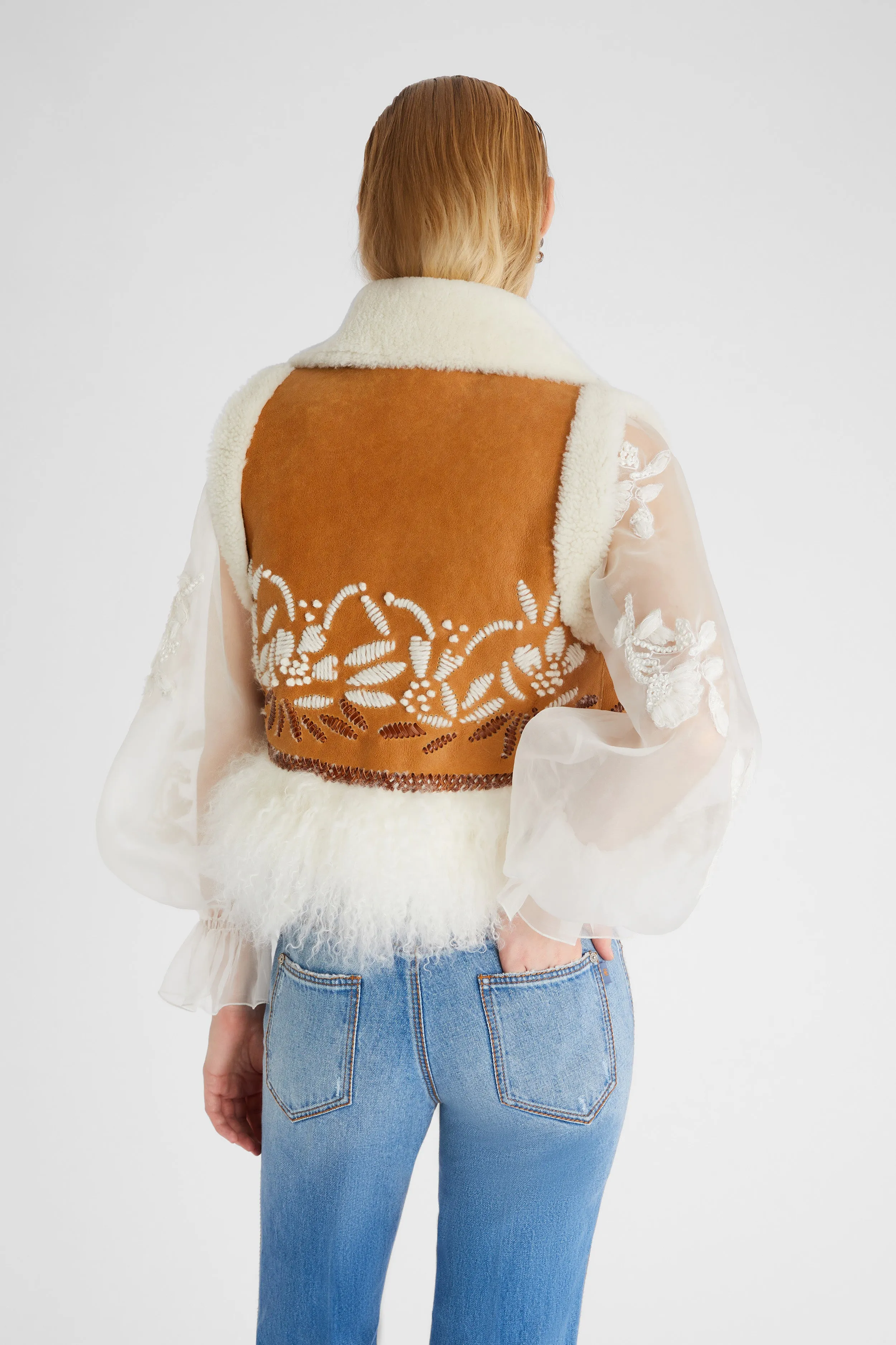 Shearling short waistcoat with handmade embroidery and fur on the bottom